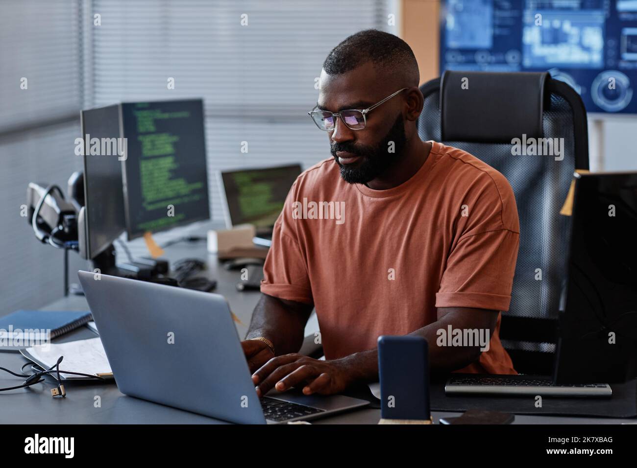 Portrait of black software engineer using computer in high technology office, data systems and programming concept, copy space Stock Photo