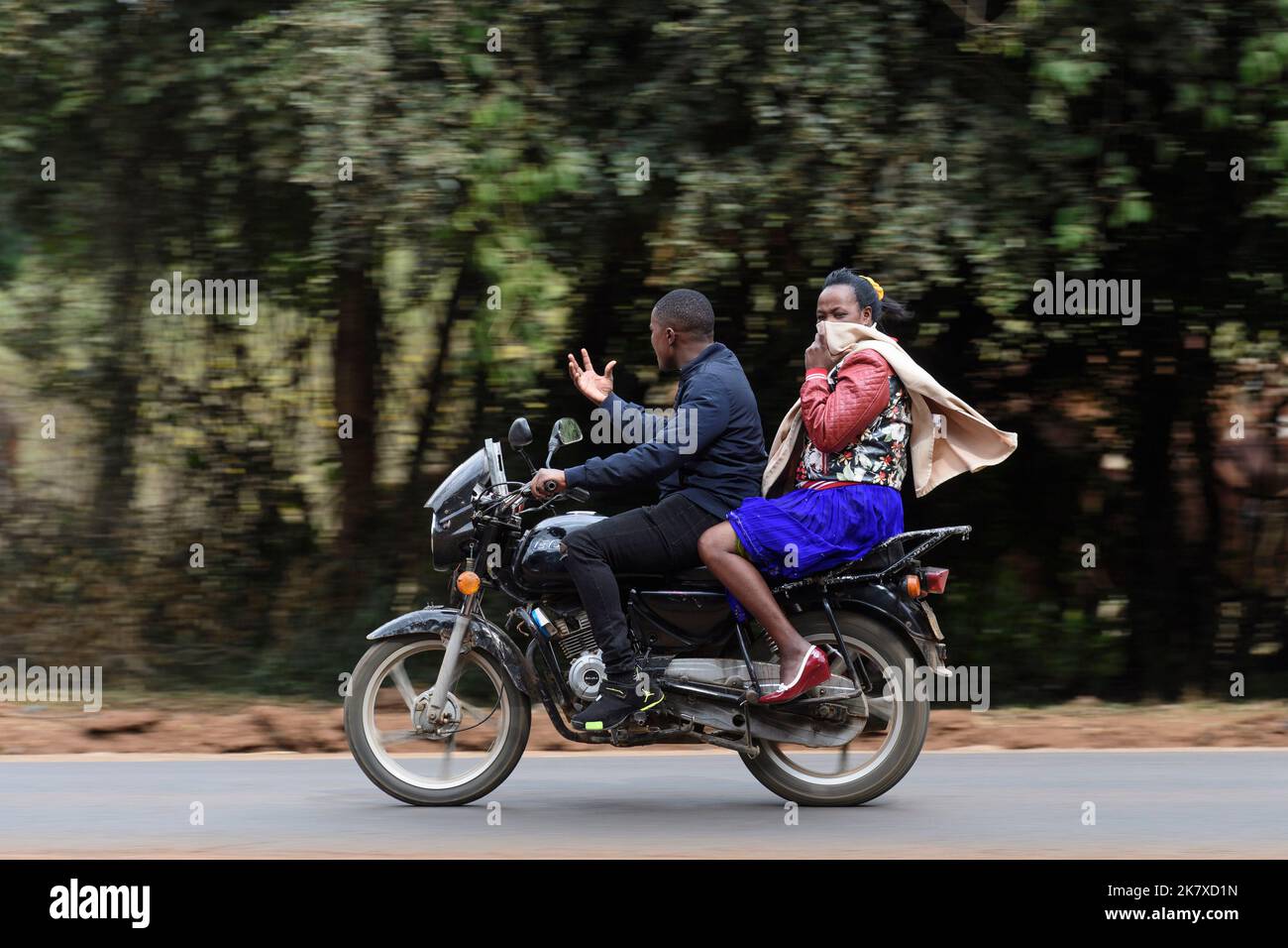 A pillion passenger riding on motorcycle taxis, know as a Boda boda, in ...