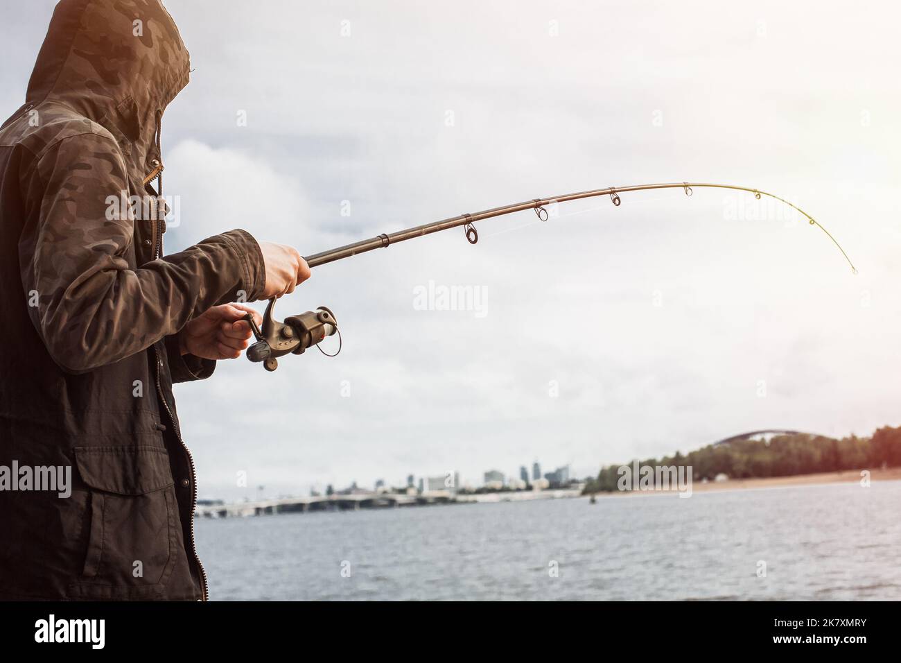 Young man fishing with a spinning on the river Stock Photo