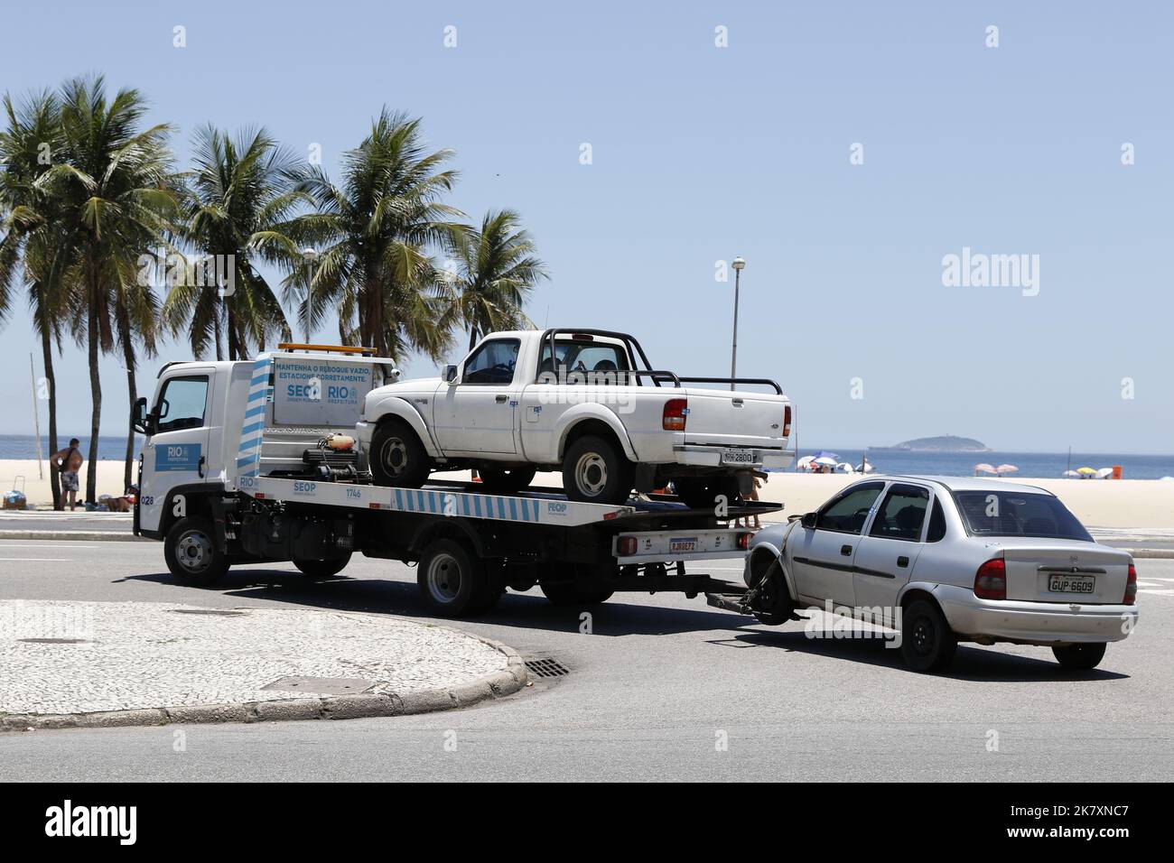 Tow truck towing impounded vehicles for traffic violations. Illegal parking, punishment and fine for irregular driving Stock Photo