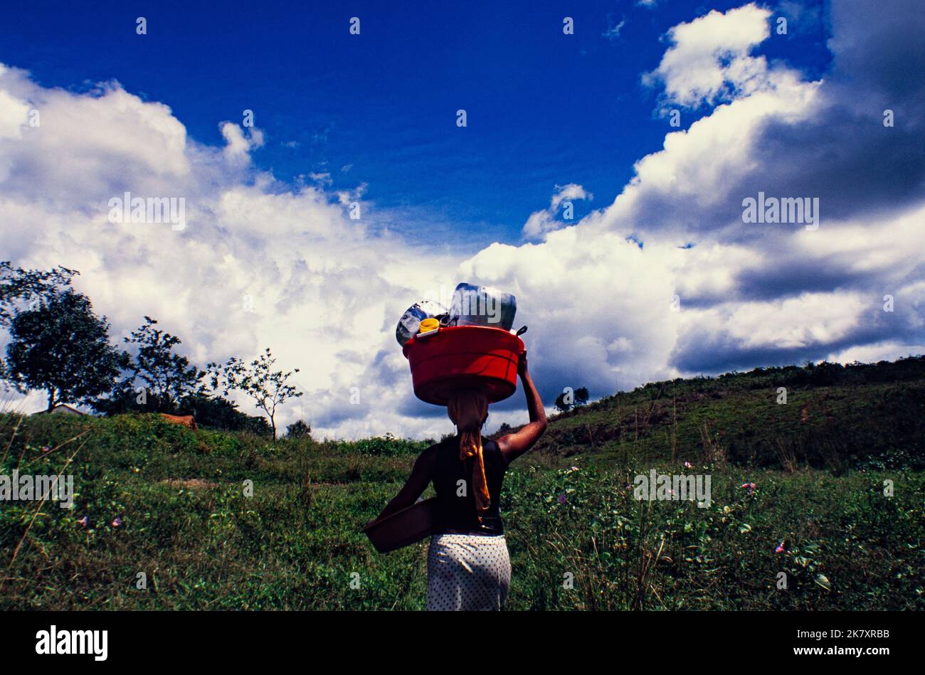 Daily life in countryside Northeastern Brazil, young black woman takes the dishes to be washed in the river. Palmares, Pernambuco State. Stock Photo