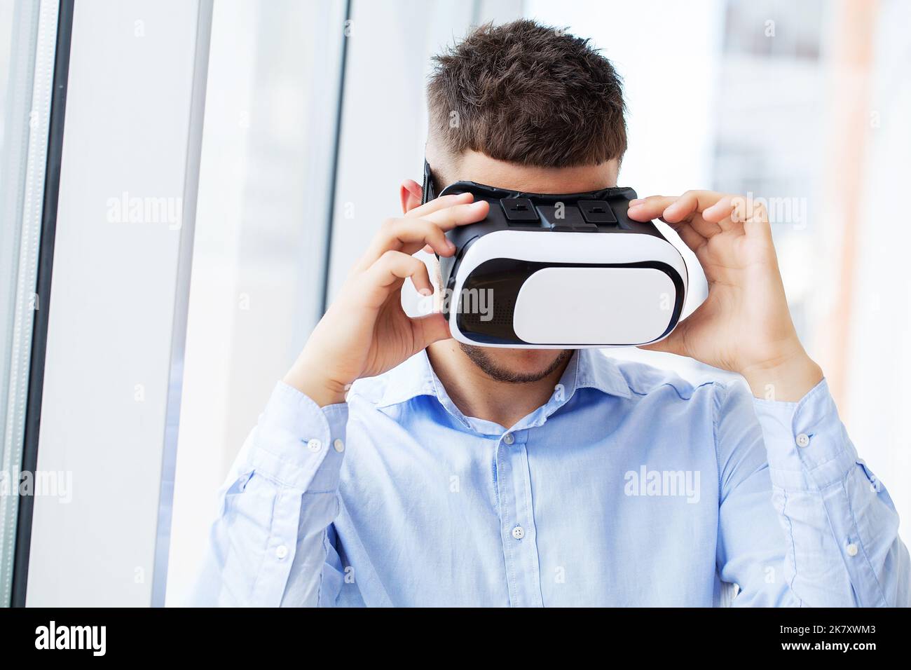 Man in virtual reality glasses interacts with app simulated interface. Stock Photo