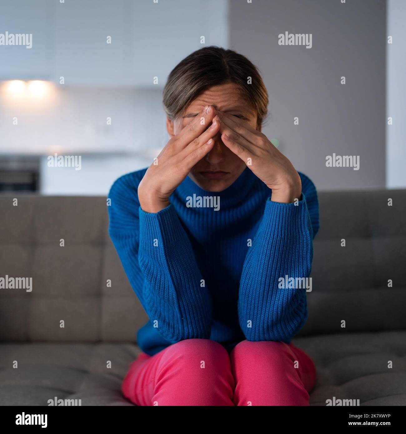 Pensive woman sitting on sofa has depression and melancholy after breaking up with boyfriend Stock Photo