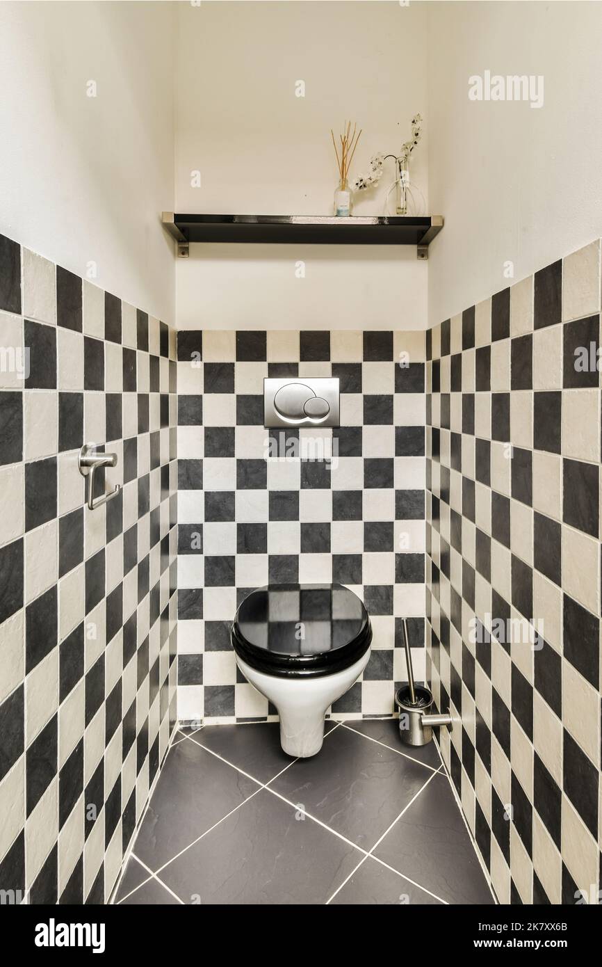 Modern toilet installed on beige wall under button and illuminated