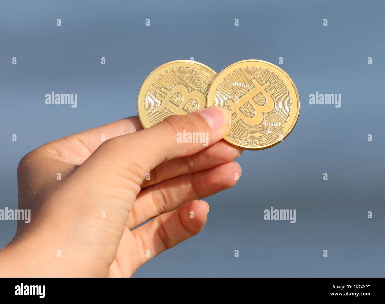 two golden coins symbolizing bitcoins in hand Stock Photo - Alamy