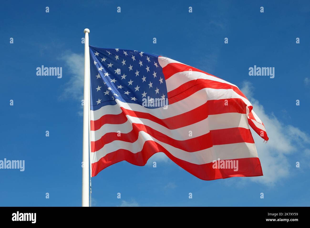 Great american flag with stars and red and white stripes on blue sky ...
