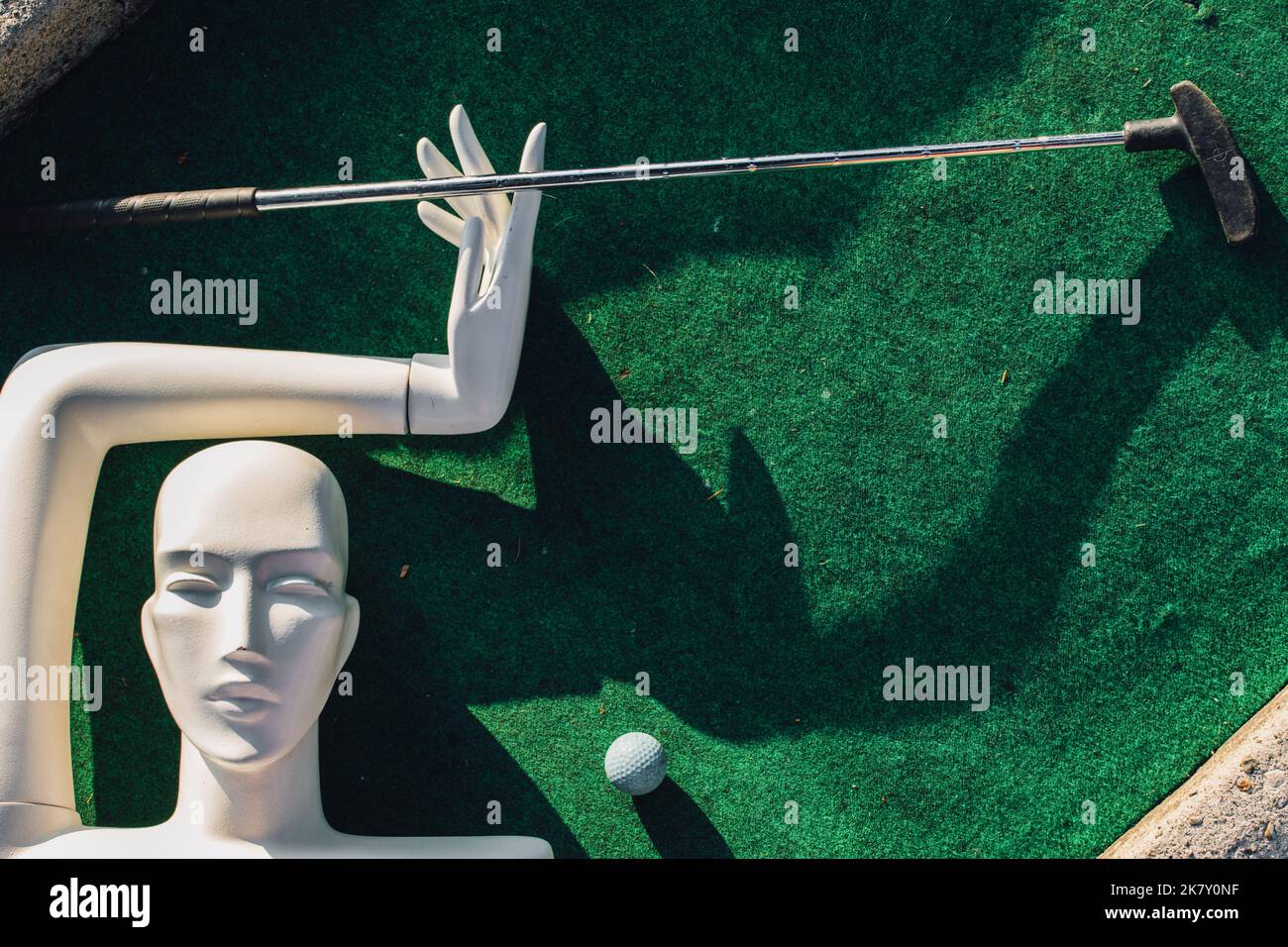 white mannequin with one arm playing mini golf Stock Photo