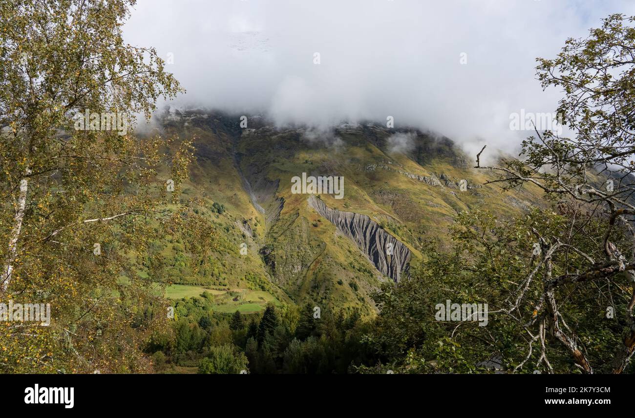 magnificent view of a long glacial valley through snow and cloud topped ...