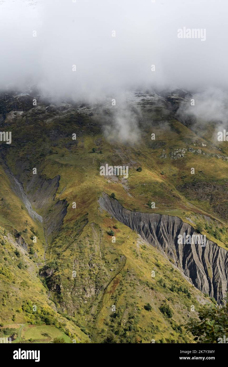 magnificent view of a long glacial valley through snow and cloud topped ...