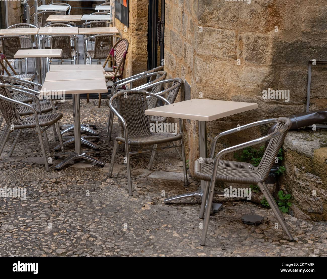 tables and chairs in a cobbled street outside a restaurant in Sarlat-la ...