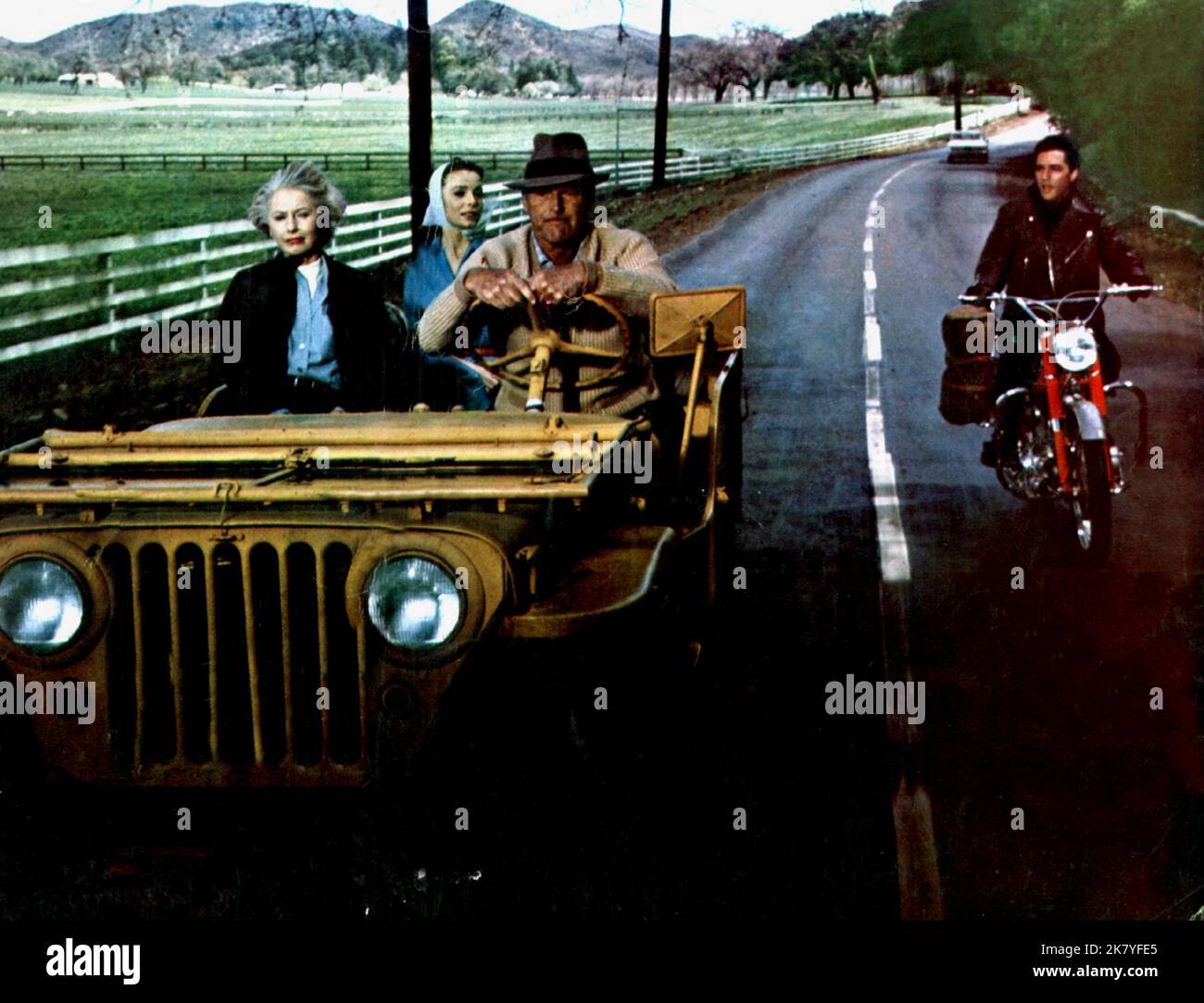 Barbara Stanwyck, Joan Freeman & Elvis Presley Film: Roustabout (USA 1964) Characters: Maggie Morgan,Cathy Lean & Charlie Rogers  / 1945 Willys Jeep Cj-2a Director: John Rich 11 November 1964   **WARNING** This Photograph is for editorial use only and is the copyright of PARAMOUNT PICTURES and/or the Photographer assigned by the Film or Production Company and can only be reproduced by publications in conjunction with the promotion of the above Film. A Mandatory Credit To PARAMOUNT PICTURES is required. The Photographer should also be credited when known. No commercial use can be granted withou Stock Photo