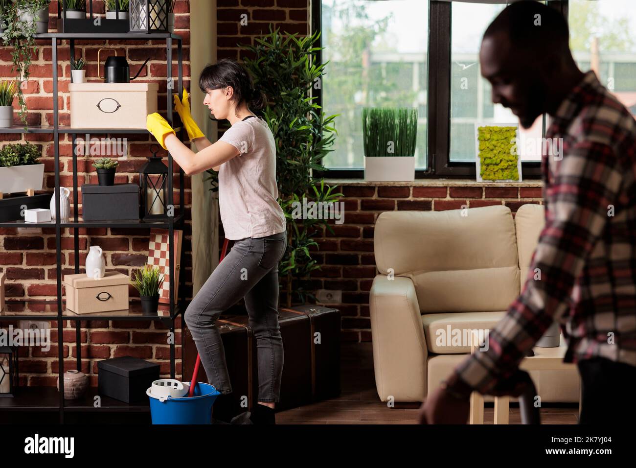 Housewife moving heavy shelves at home african american husband helps
