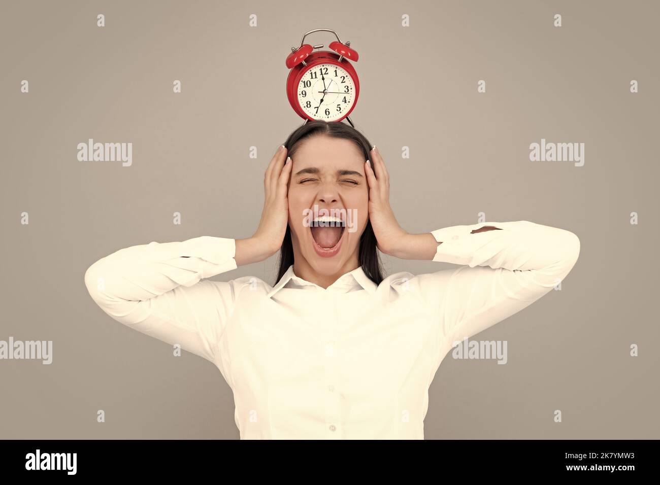 Photo of shocked girl hold alarm clock, crazy girl isolated gray