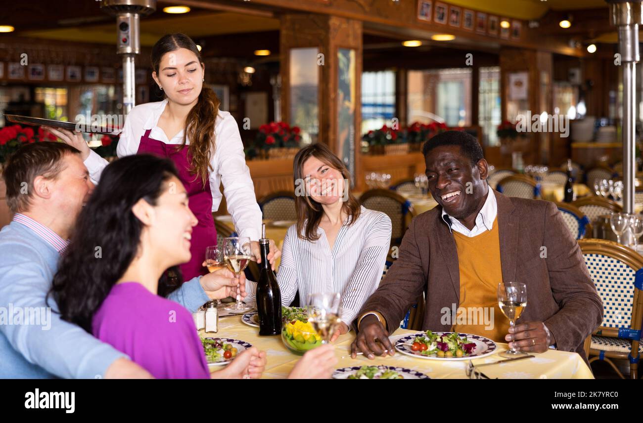 Positive men and women on double date in restaurant Stock Photo