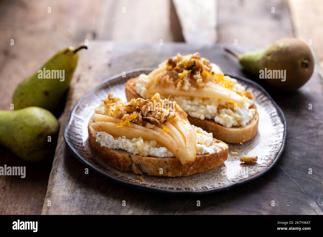 Toast with ricotta cheese, pears, walnuts and honey Stock Photo