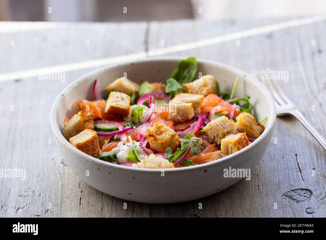 Salad with smoked salmon, pickled onions and croutons Stock Photo