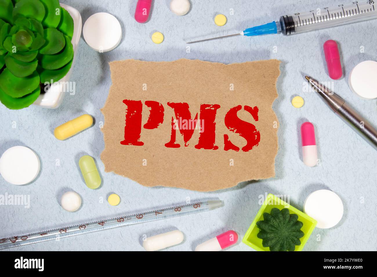 The words pms, is written on white paper on yellow background Stock Photo