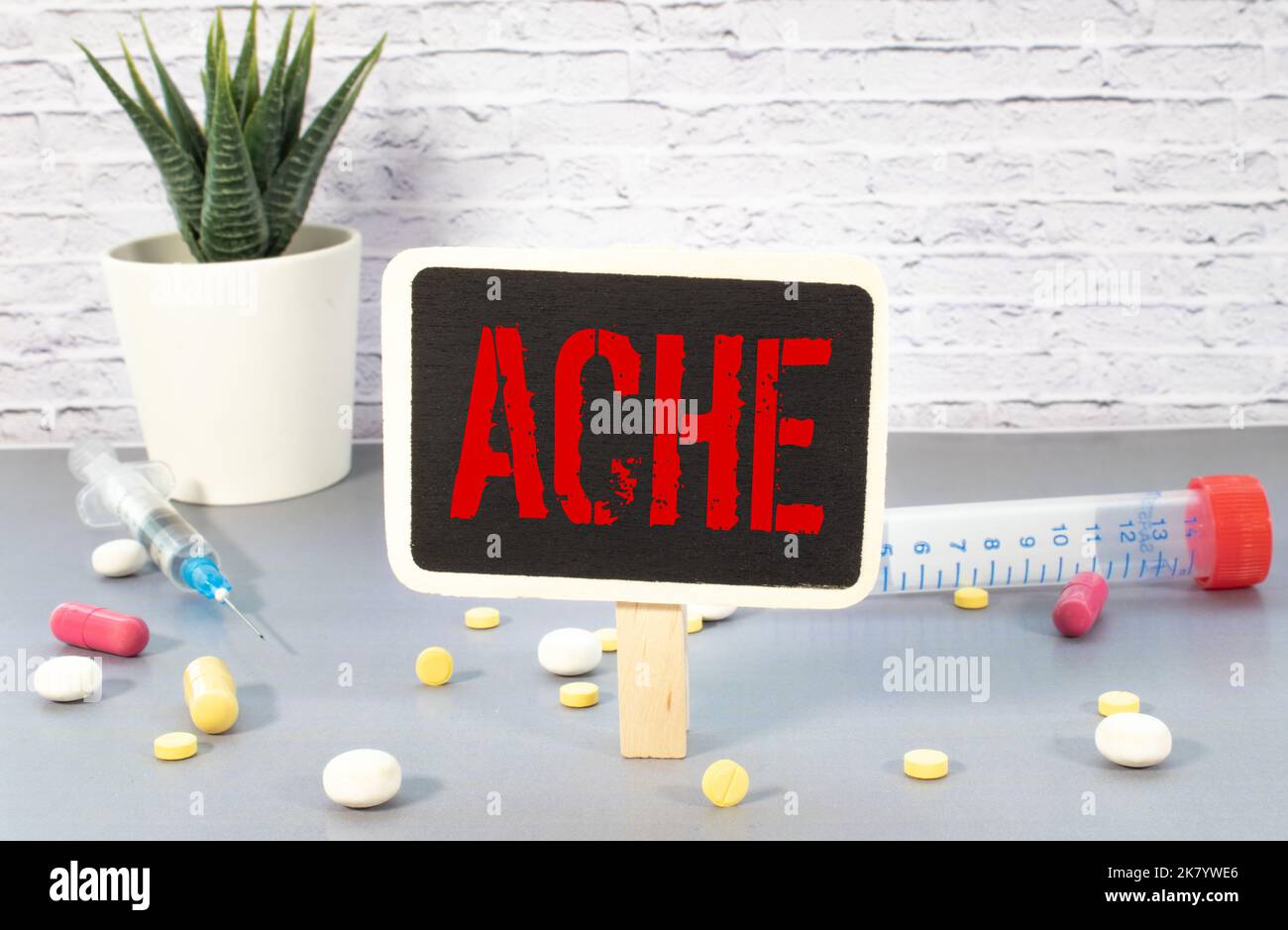 Wooden block form the word Ache with stethoscope on the doctor's desktop. Stock Photo
