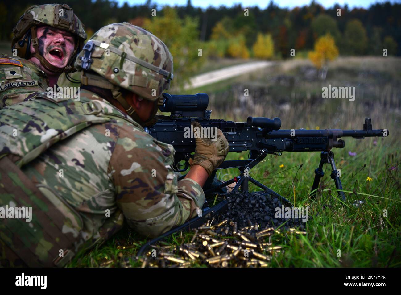U.S. Army Spc. Jacob Lancaster, an assistant M240b gunner assigned to Bull Troop, 1st Squadron, 2nd Cavalry Regiment calls out for more ammunition during a live support by fire training at the Grafenwoehr Training Area, Germany, Oct. 16, 2022. 2nd Cavalry Regiment provides V Corps, America’s forward-deployed corps in Europe, with combat-credible forces capable of rapid deployment throughout the European theater to defend the NATO alliance. (U.S. Army photo by Kevin Sterling Payne) Stock Photo