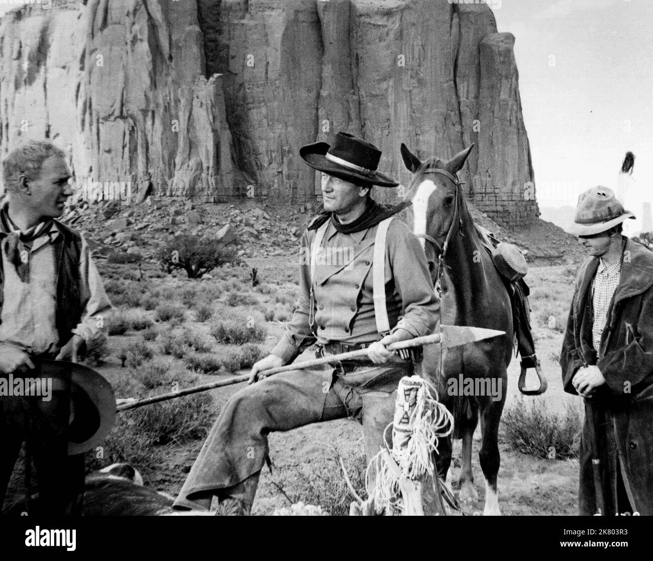 John Wayne Film: The Searchers (USA 1956) Characters: Ethan Edwards  Director: John Ford 07 March 1956   **WARNING** This Photograph is for editorial use only and is the copyright of WARNER BROS. and/or the Photographer assigned by the Film or Production Company and can only be reproduced by publications in conjunction with the promotion of the above Film. A Mandatory Credit To WARNER BROS. is required. The Photographer should also be credited when known. No commercial use can be granted without written authority from the Film Company. Stock Photo