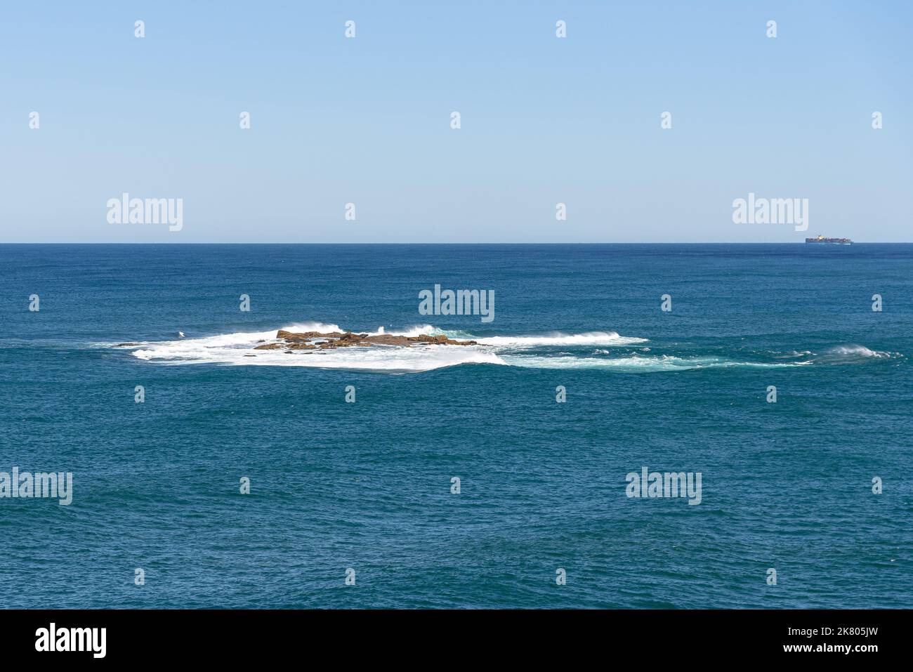 Waves crashing onto Wedding Cake Island in the Tasman Sea Stock Photo