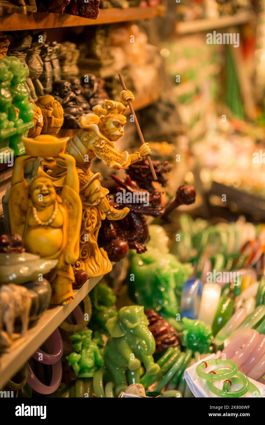 Carved figurines of the Buddha, the Monkey King and other auspicious characters in Chinese culture for sale in Yau Ma Tei, Kowloon, Hong Kong Stock Photo