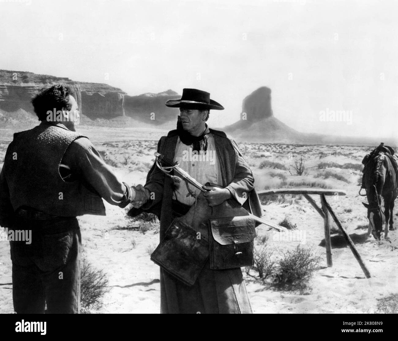 John Wayne Film: The Searchers (USA 1956) Characters: Ethan Edwards  / Location: Monument Valley, Utah Director: John Ford 07 March 1956   **WARNING** This Photograph is for editorial use only and is the copyright of WARNER BROS. and/or the Photographer assigned by the Film or Production Company and can only be reproduced by publications in conjunction with the promotion of the above Film. A Mandatory Credit To WARNER BROS. is required. The Photographer should also be credited when known. No commercial use can be granted without written authority from the Film Company. Stock Photo