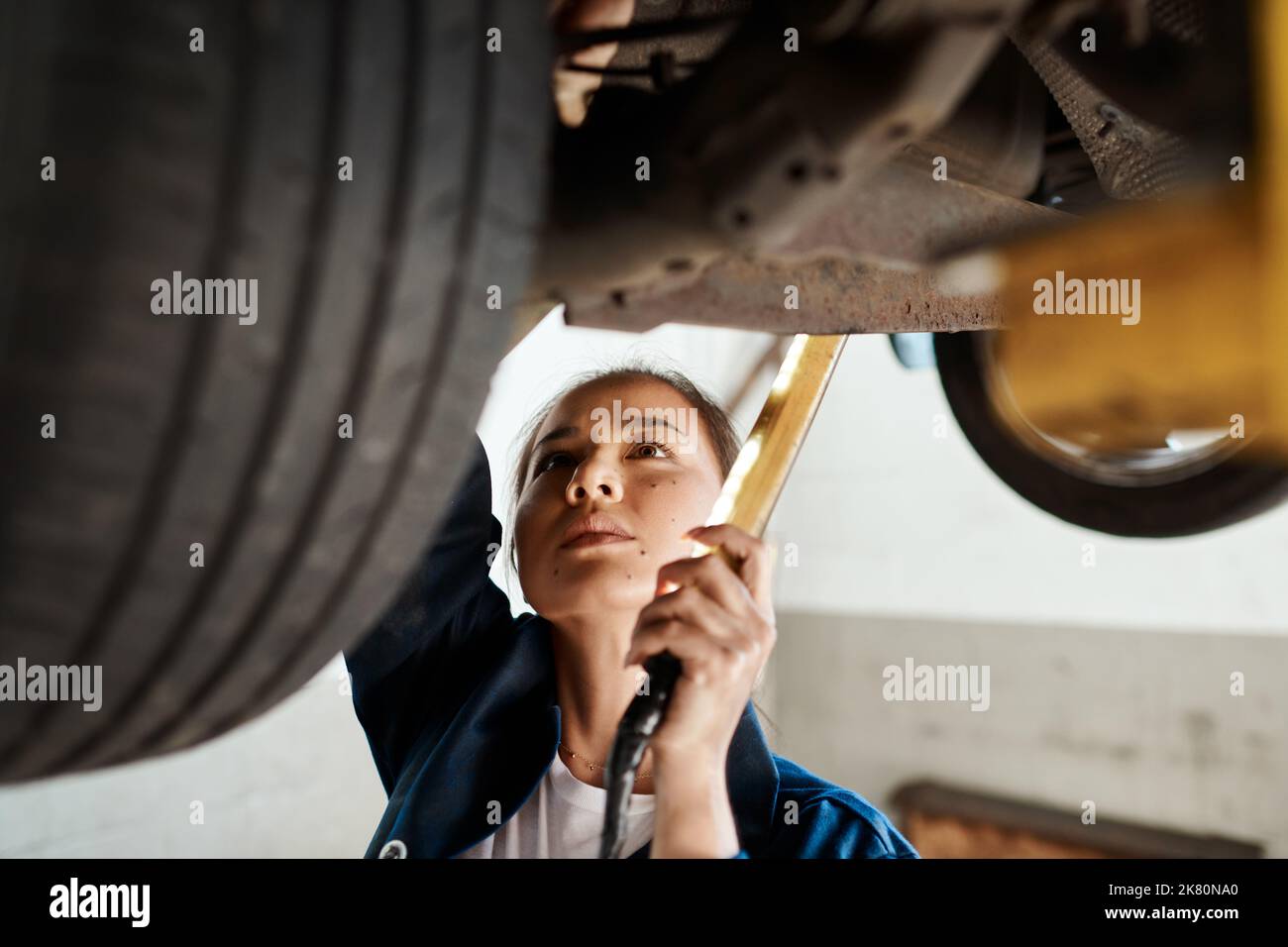 My knowledge of cars allows me to diagnose problems much quicker. a female mechanic working