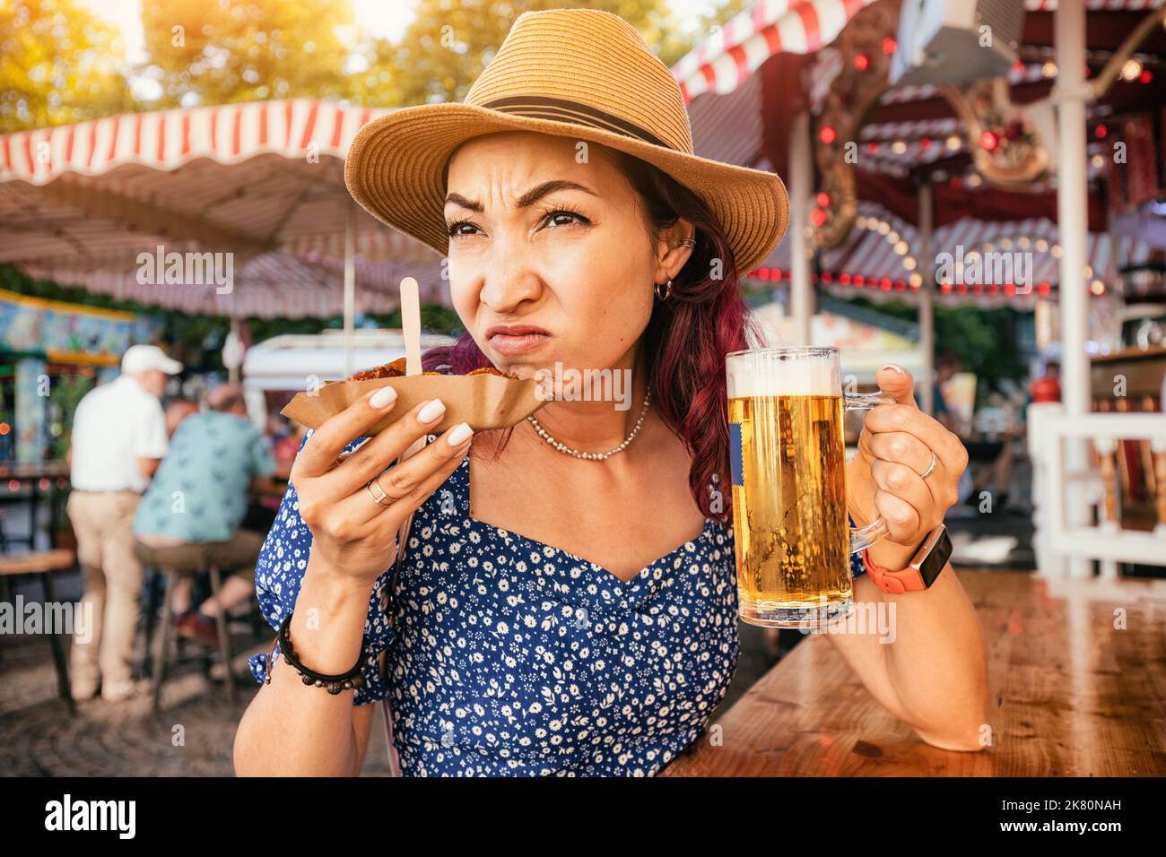 A girl in a pub sniffs a spoiled currywurst sausage and makes a