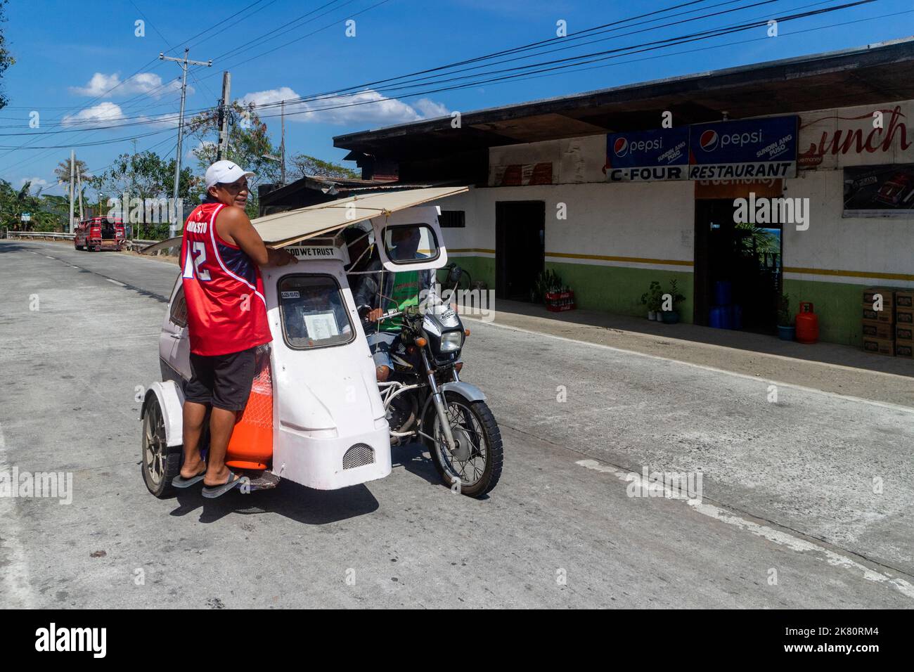 A passenger riding a tricycle in Iloilo, Philippines Stock Photo
