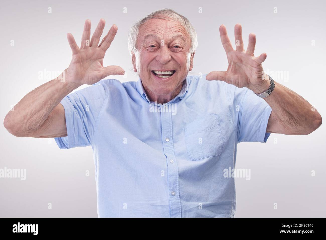 Catch me if you can. Studio shot of a senior man making a playful gesture against a grey background. Stock Photo