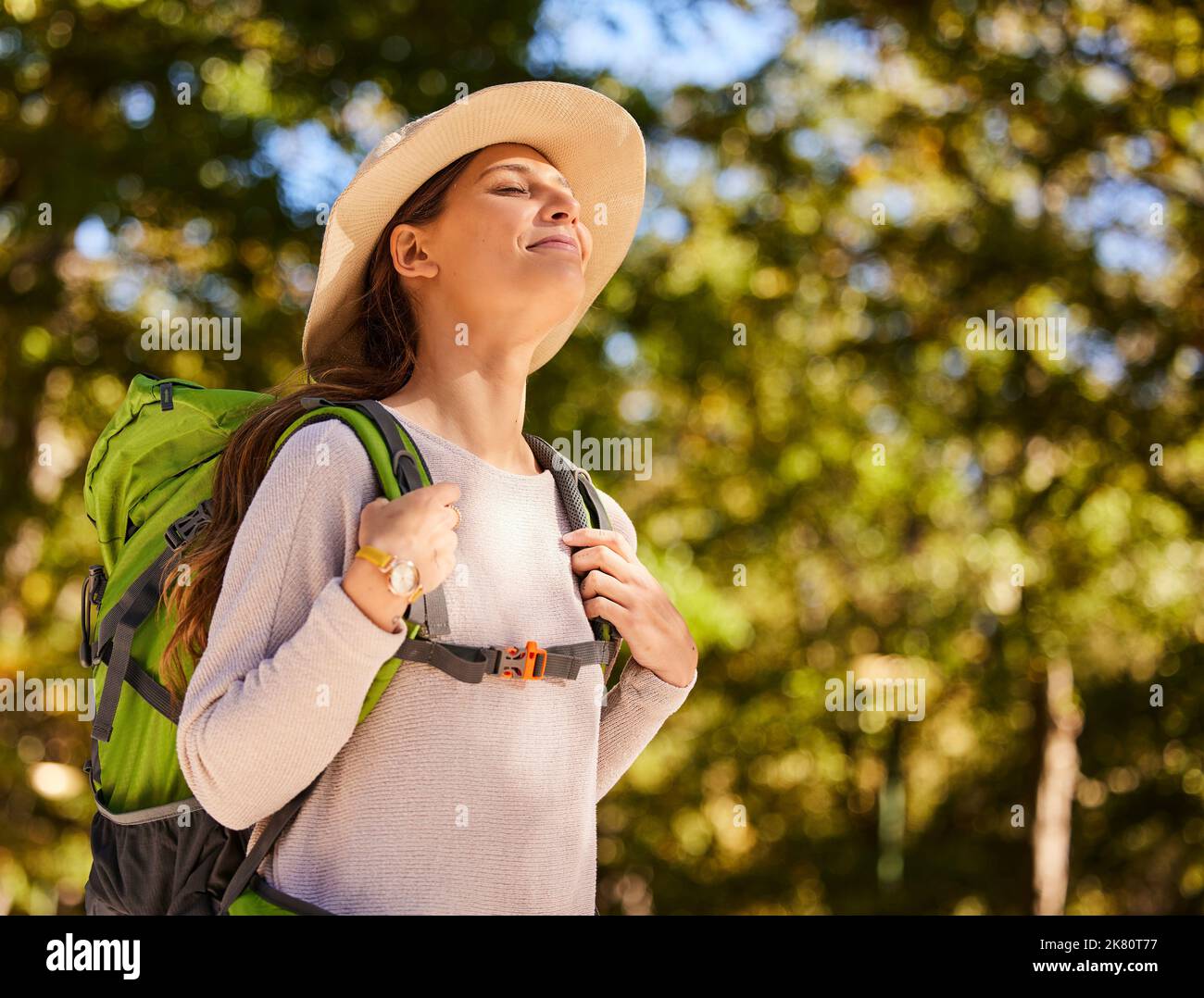 Hiking, travel and woman backpacking in the forest for outdoor wellness, adventure or eco friendly lifestyle. Breathing, trekking and carbon footprint Stock Photo