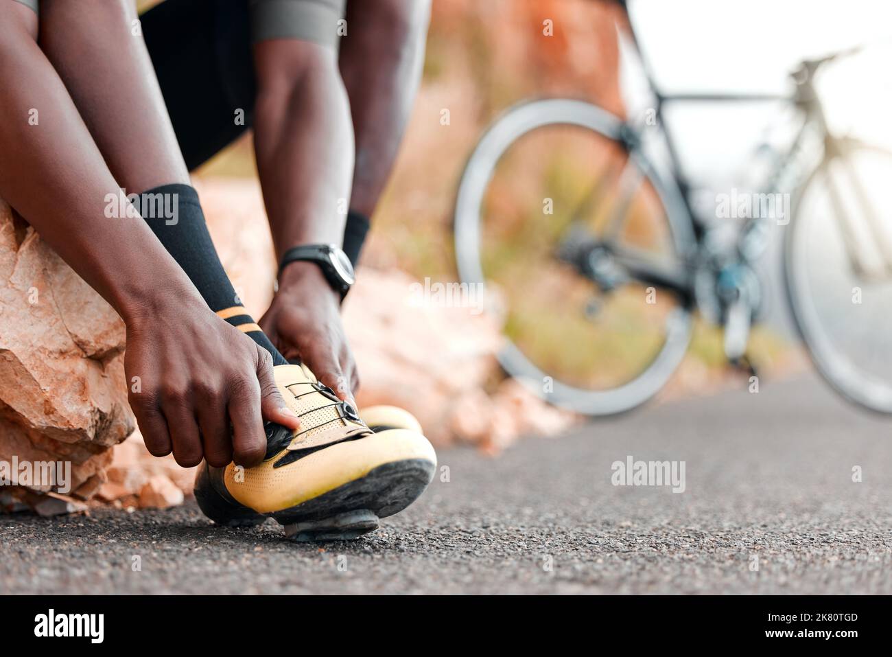 Fitness, ready and man with cycling shoes by his bicycle starting his workout, cardio exercise and training journey. Sports, healthy and African Stock Photo