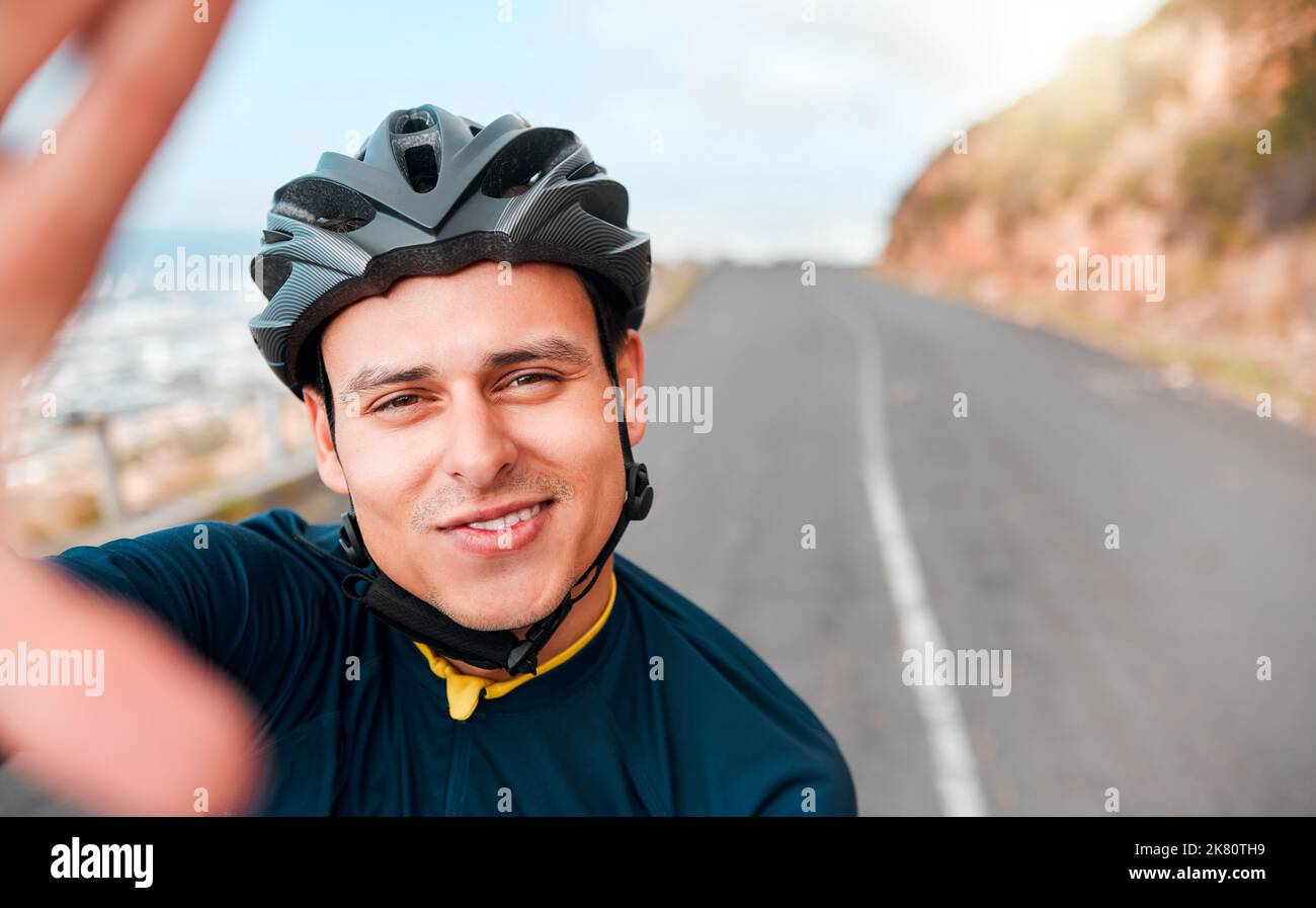 Selfie, fitness and man cycling in the road on the mountains in Switzerland for adventure, peace and freedom. Face portrait of a young, happy and free Stock Photo