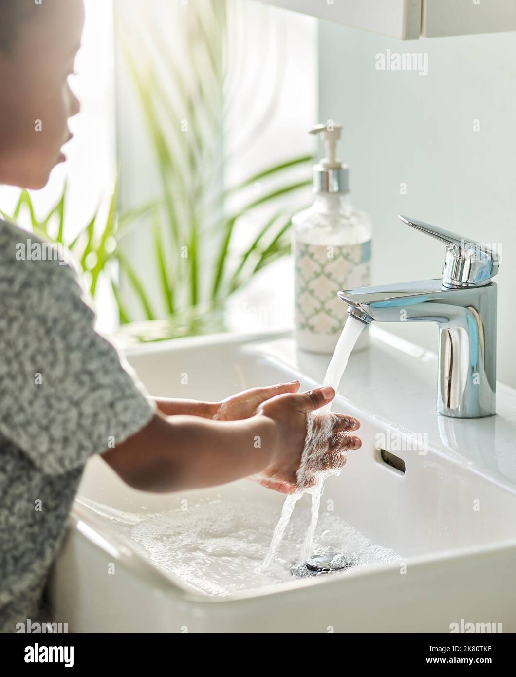 Keep clean, stay healthy. Closeup shot of an unrecognisable boy washing his hands at a tap in a bathroom at home. Stock Photo