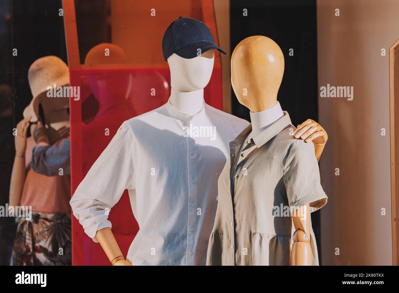 Couple of mannequins in fashionable clothes are tender hugging