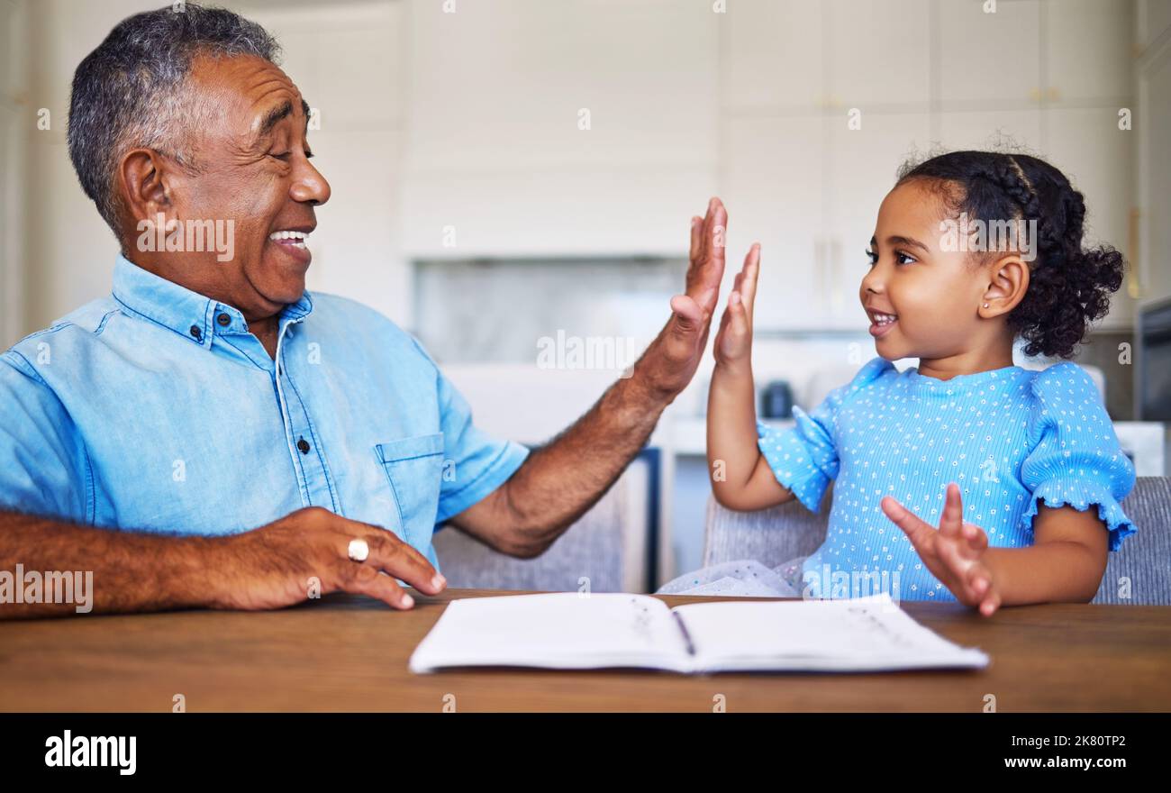 High five, child learning and black family grandfather support, helping or care for home education or language development motivation. Elderly man Stock Photo