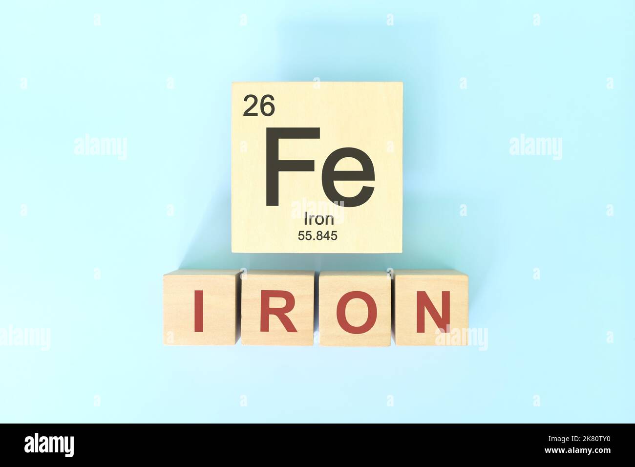 Iron chemical element symbol with atomic mass and atomic number in wooden blocks flat lay