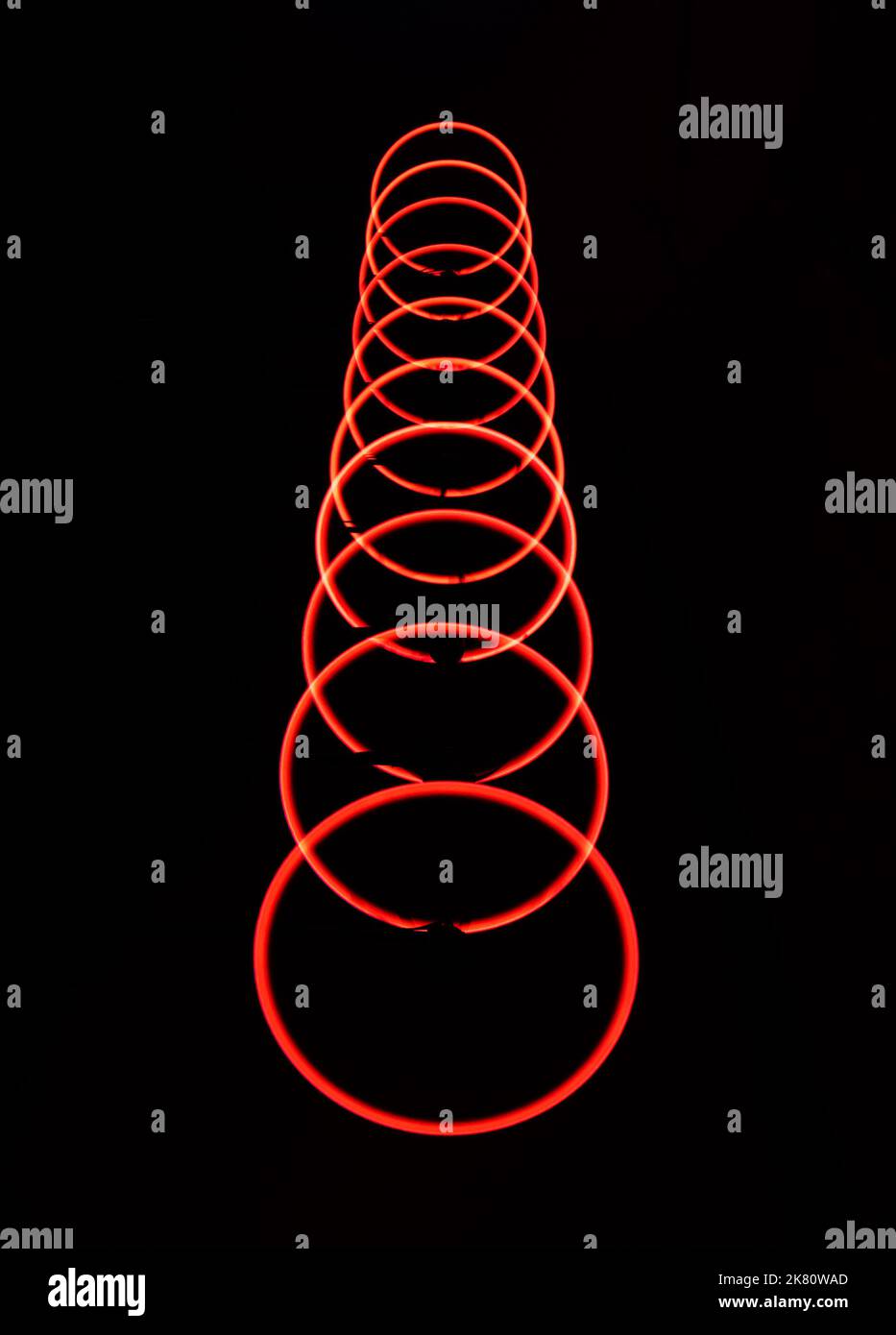 Whirling red light circles on black background Stock Photo