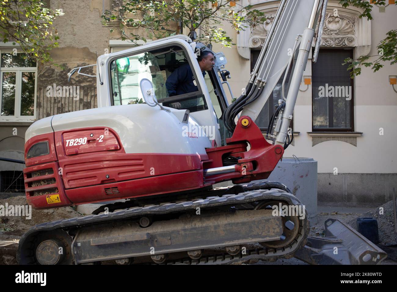 Belgrade, Serbia, Oct 18, 2022: A worker operating an excavator to repair street in Zemun Stock Photo