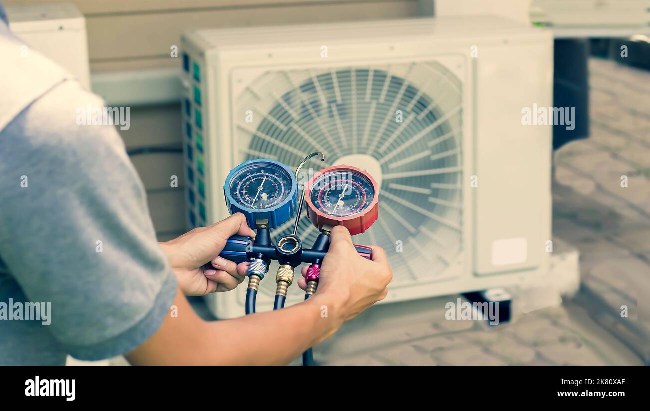 Air conditioner repairman using electricity meter to check air