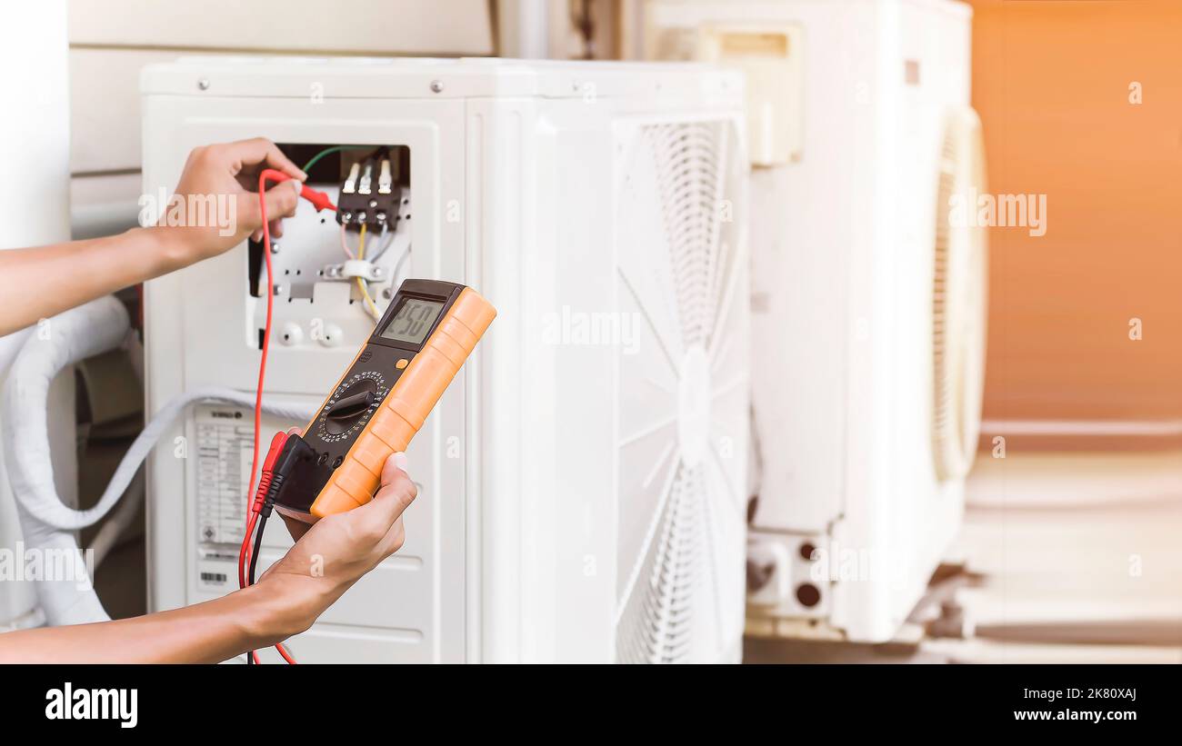 Air conditioner repairman using electricity meter to check air