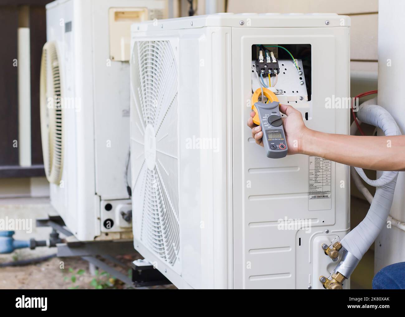 Air conditioner repairman using electricity meter to check air