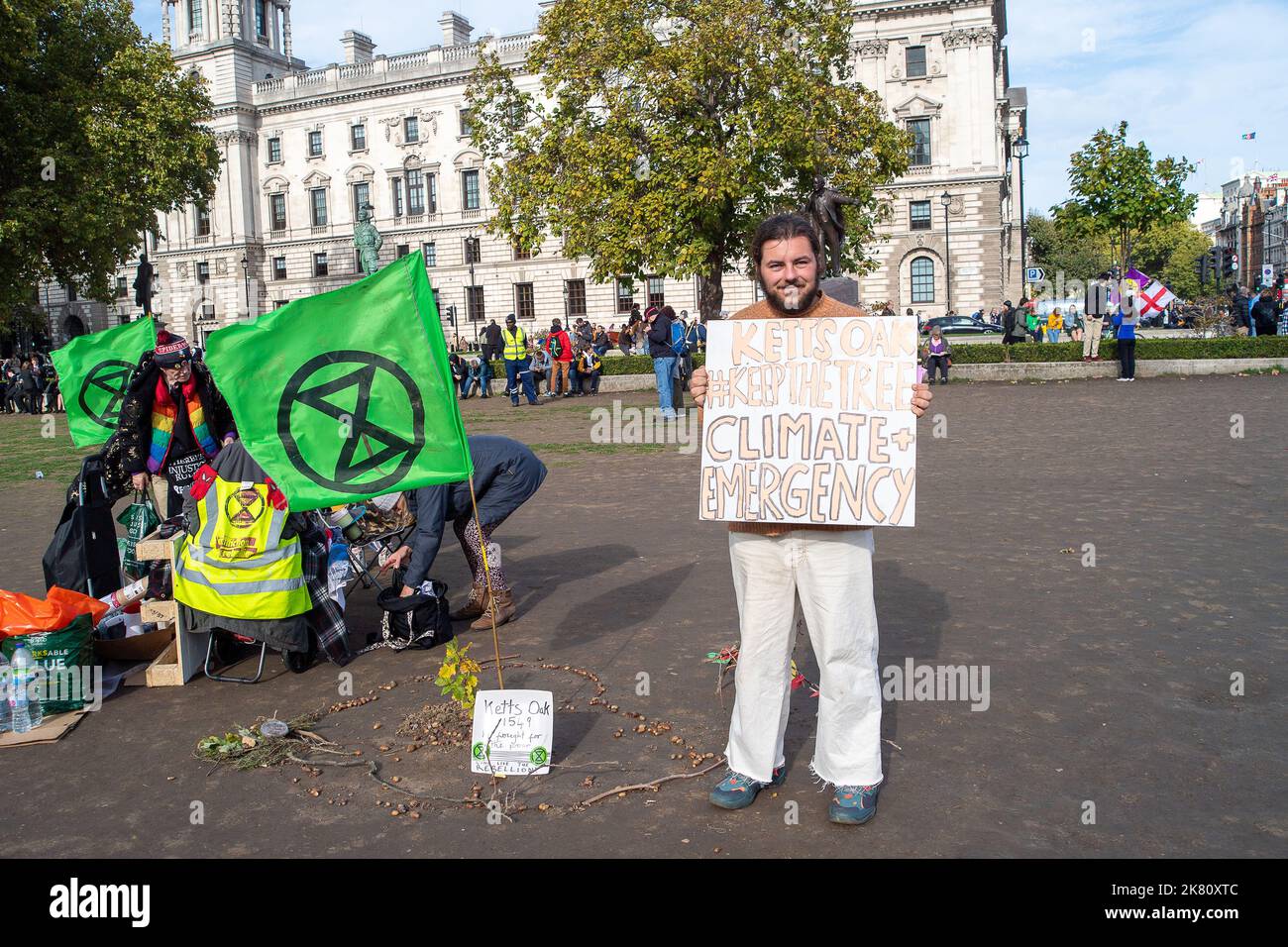 Westminster, London, UK. 19th October, 2022. Climate activists from Extinction Rebellion have planted a symbolic oak tree sapling in the ground at Parliament Square opposite the Palace of Westminster. The sapling is from the famous ancient Kett's Oak in Norfolk. The tree is the traditional location where in 1549 Robert and William Kept addressed a group of men in what was to become Kett's Rebellion. Their grievances concerned the enclosing of the common lands and the rising cost of living. Credit: Maureen McLean/Alamy Live News Stock Photo