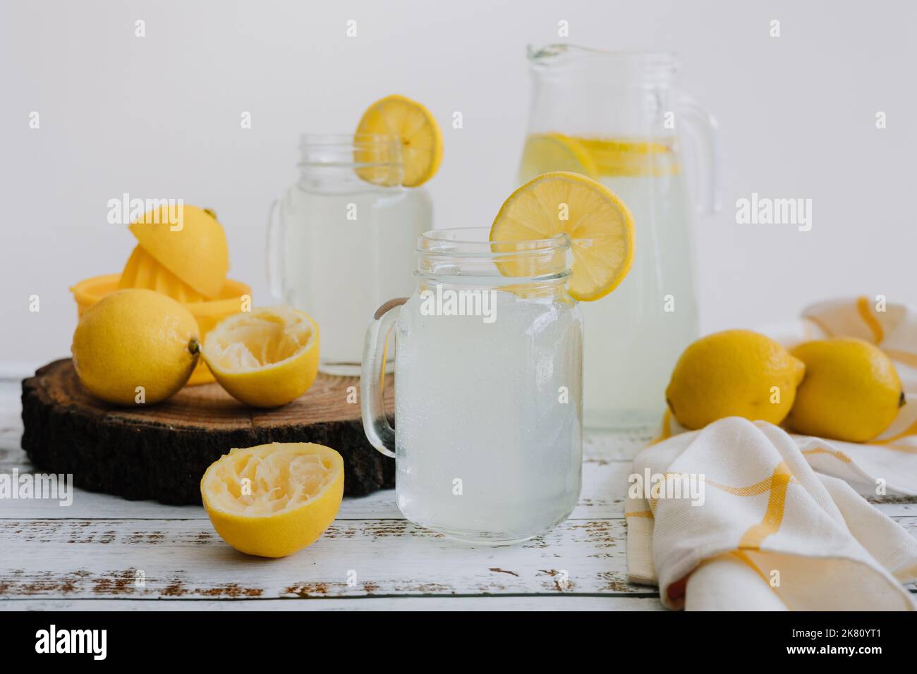 Jar glass of lemonade drink with yellow lemons or lime on a white background in Latin America Stock Photo