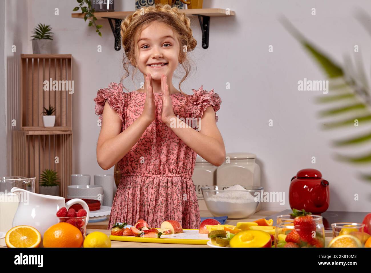 Cute beautiful girl with a modern hairstyle is cooking at a kitchen