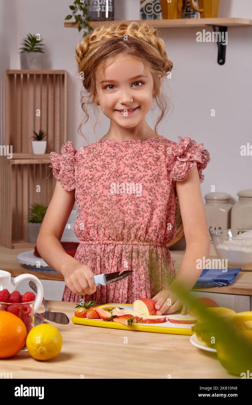 Cute beautiful girl with a modern hairstyle is cooking at a kitchen