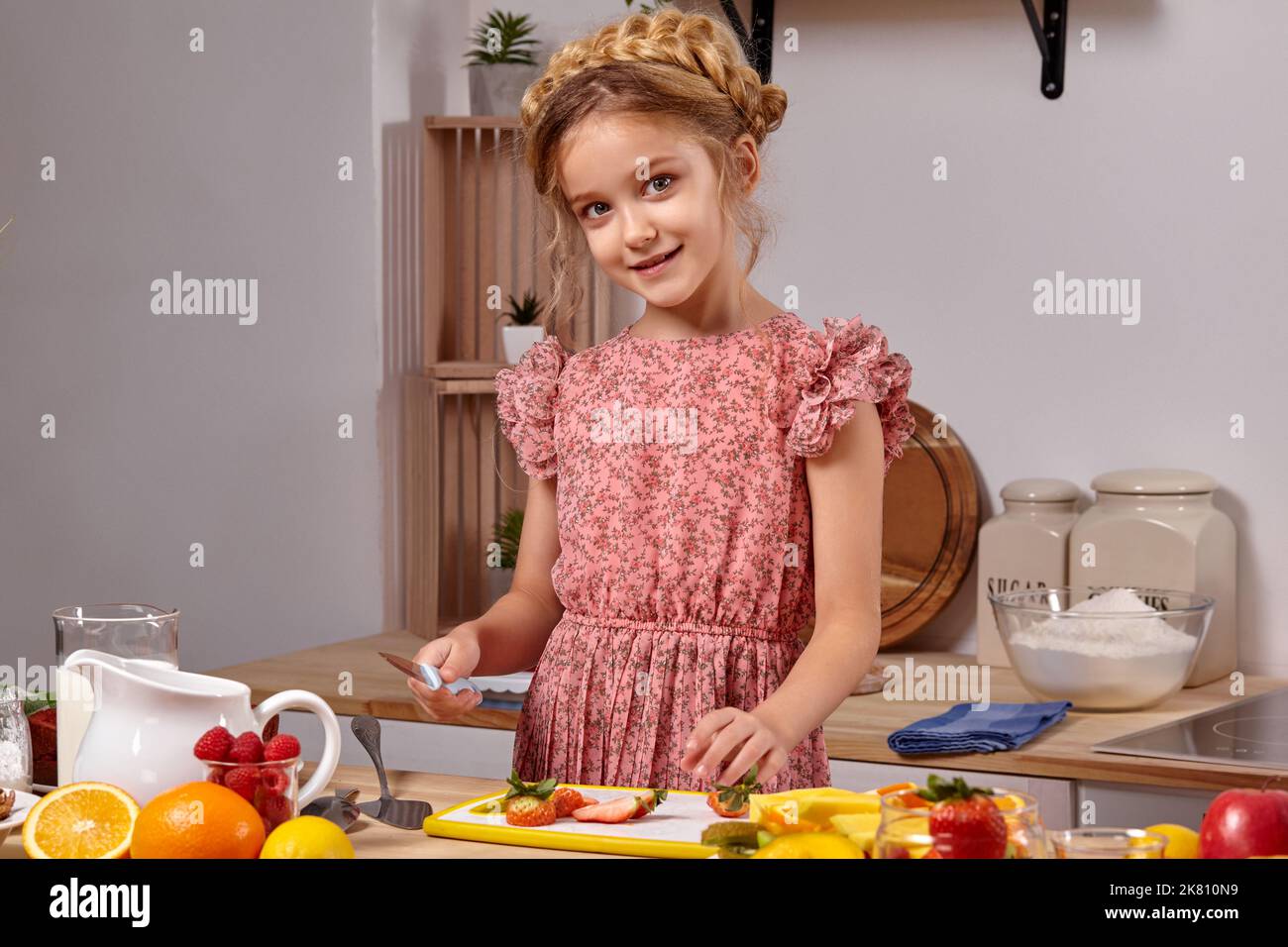 Cute beautiful girl with a modern hairstyle is cooking at a kitchen