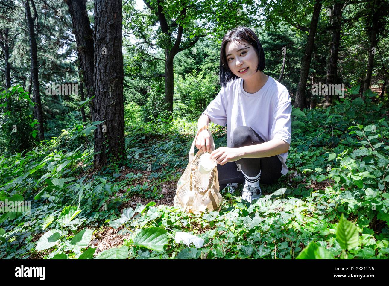 korean young woman hiking and plogging picking up litter, garbage Stock Photo Alamy
