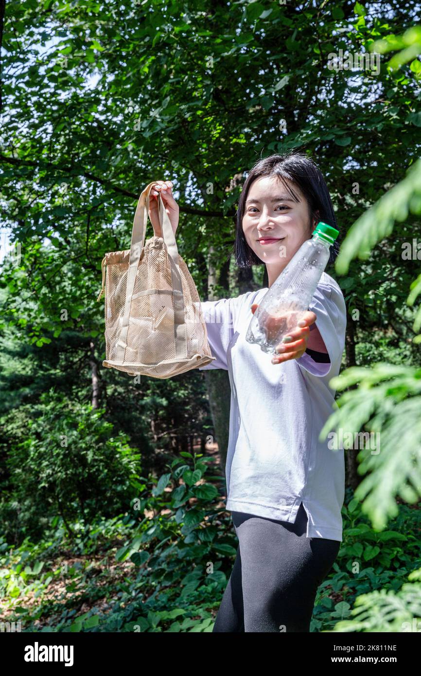 korean young woman hiking and plogging picking up litter, garbage Stock Photo Alamy